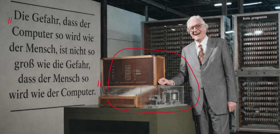 Im Unterricht annotierte historische Fotografie einer frühen Computeranlage mit ihrem Konstrukteur
